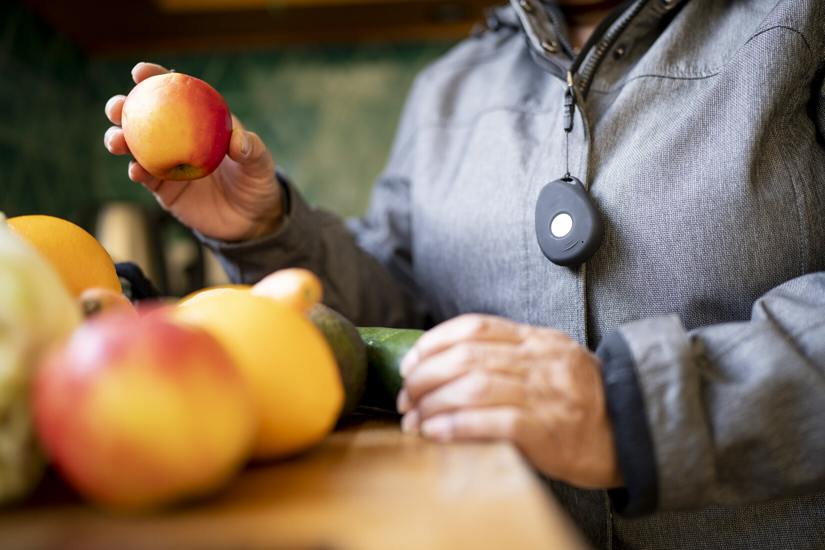 afbeelding van een man met een alarmknop die een appel vast houdt